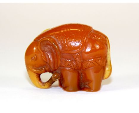 A Japanese reconstituted amber netsuke of an elephant, H. 3cm.