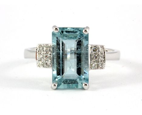 A 14ct white gold (stamped 585) ring set with a baguette cut 2.93ct aquamarine and diamond set shoulders, (N).