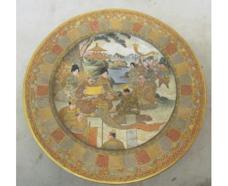 A 19th Century satsuma plate highly decorated with scenes of dignitaries and geisha in garden with pagoda and river to backgr