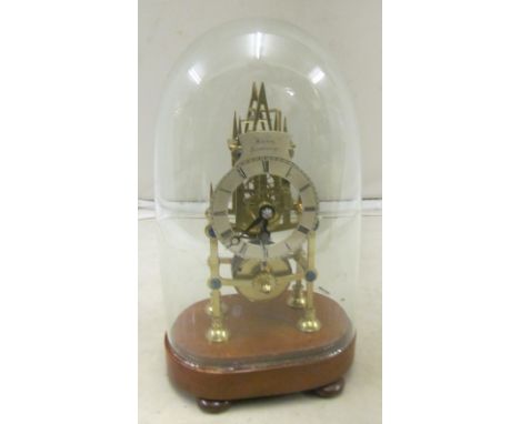 A skeleton clock under glass dome
