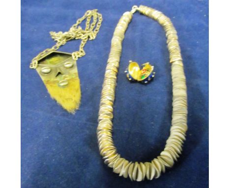 A silver chain necklace, enamel egg pendant and face pendant