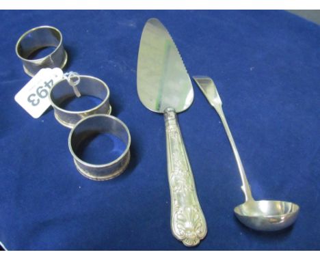 Three silver napkin rings, silver ladle and a cake slice