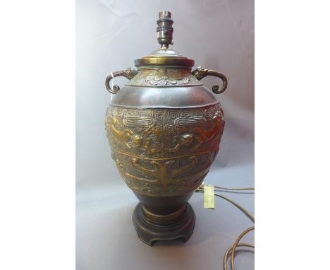 A contemporary Chinese style brass table lamp of baluster form and raised on ebonised base, H:42cm