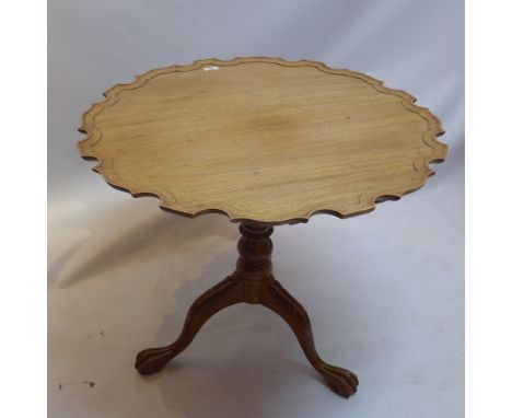 A Chippendale style walnut tilt top table with pie crust top raised on bird cage mechanism, tripod base and ball and claw fee