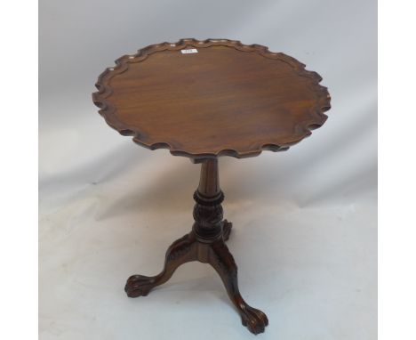 A Chippendale style mahogany tilt top table with pie crust top raised on bird cage mechanism, tripod base and ball and claw f