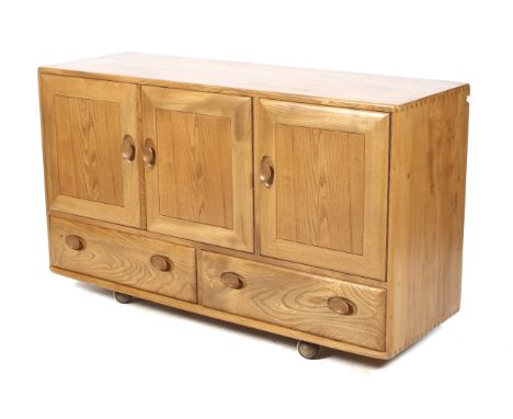 A circa 1960s Ercol 468 elm sideboard. Having a twin door cupboard alongside a single door cupboard with drawer, above two dr