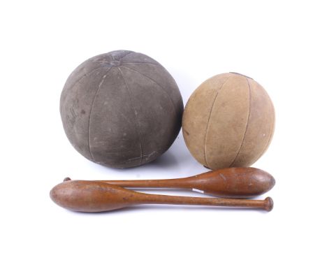 Two vintage suede medicine balls and two wooden clubs. Largest ball, H28cm, the clubs, L51cm