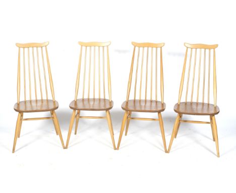 A set of four mid-century blonde Ercol Goldsmith stick back chairs. On circular tapering supports united by H stretchers. H97