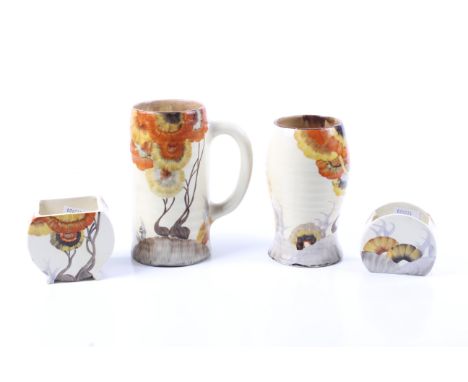 Four pieces of Clarice Cliff Bizarre in the 'Rodanthe' pattern. Comprising a vase, a jug, a pot and a preserve pot (missing c