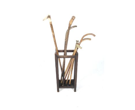 A collection of assorted vintage walking sticks and a stand. Early 20th century oak stand, L31cm x D28cm x H72cm