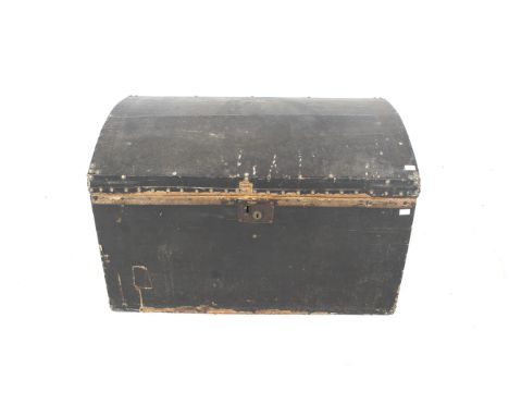 A vintage dome topped travelling trunk. The exterior lined in black leather with twin handles and brass studded details, the 