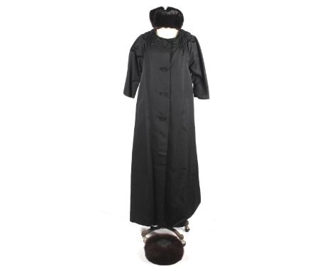 A vintage ladies black coat and two fur trimmed hats. The coat with a gathered neckline, three quarter length sleeves and fou