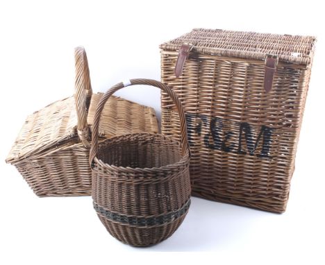 Three pieces of wicker. Comprising a single handled basket, H42cm, a picnic hamper, H44cm, and a basket with leather straps m