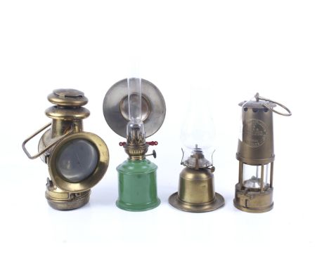 Four oil lamps. Comprising a Protector Lamp & Lighting Co. Ltd miners lamp, H25cm, a brass carriage lamp and two oil lamps wi