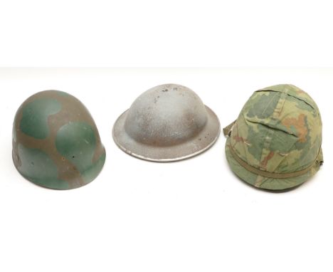 A British WWII steel helmet, an Army issue steel helmet with camouflage cover and Ground Troops liner and a another liner (3)