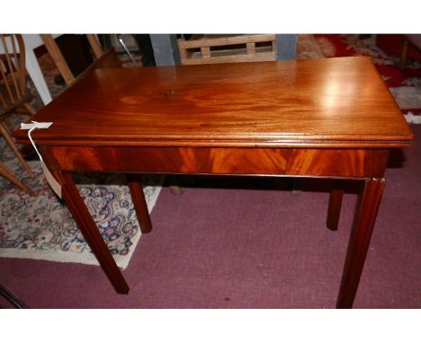 A 19th century mahogany card table raised on moulded legs 