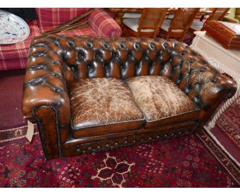 A Chesterfield two seater sofa, with brown leather button back upholstery 