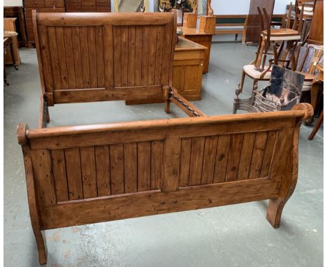 A 20th century hardwood king sized sleigh bed, the headboard 161cmW and 132cmH, the foot 92cmH, with rails and slats