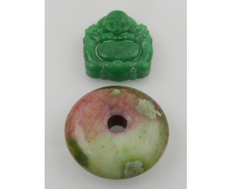 A Chinese red and green jade bi disk pendant, together with a green hardstone pendant, in the from of Buddha. (2)