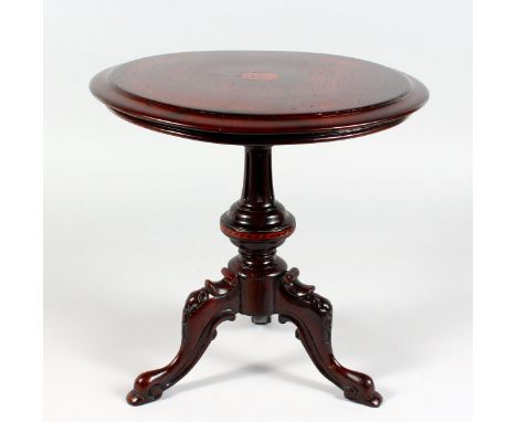 A miniature tilt top tripod table