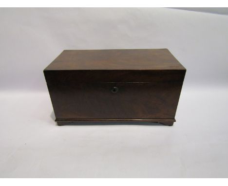 A George III mahogany tea caddy of square form, the lid opening to reveal two compartments and central  bowl well, on shaped 
