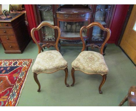 Circa 1840 a set of four walnut chairs with carved decoration the serpentine front seats on scroll foot cabriole legs and cer