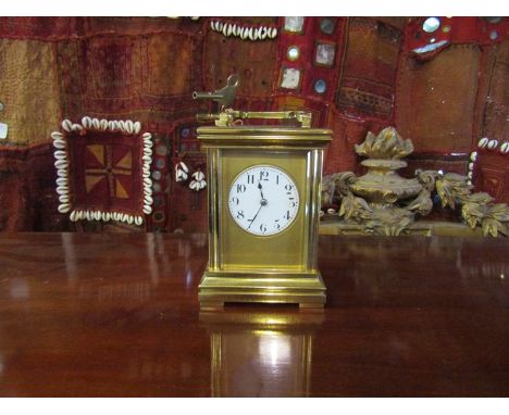 An early 20th Century brass carriage clock with white enamel face, Arabic numerals, 16cm tall