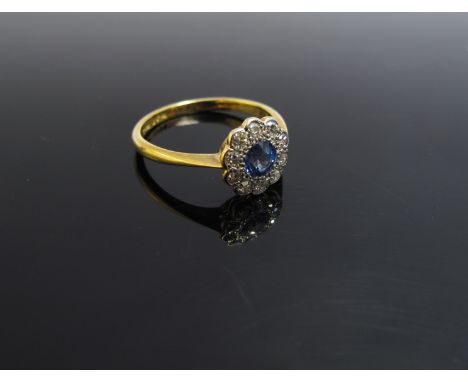 An 18ct gold platinum set sapphire and diamond daisy ring, size M, 2.2g