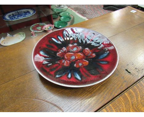 A Poole pottery charger, deep red and splash design centre 