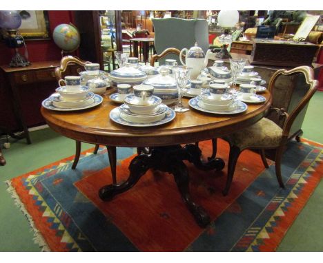 A Victorian walnut tilt top table on curved base, ceramic castors 