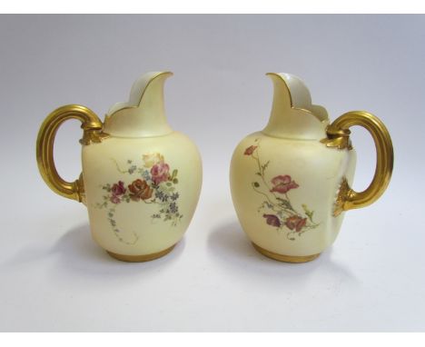 A pair of Royal Worcester jugs handpainted with floral sprays, gilt enriched handles, rim and foot. No. 1094 to base, 18cm hi