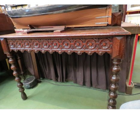 A late Victorian carved oak hall table the plank top on bobbin turned legs      