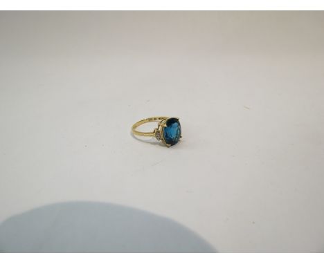 A 10ct yellow gold blue topaz ring flanked by diamonds, size L