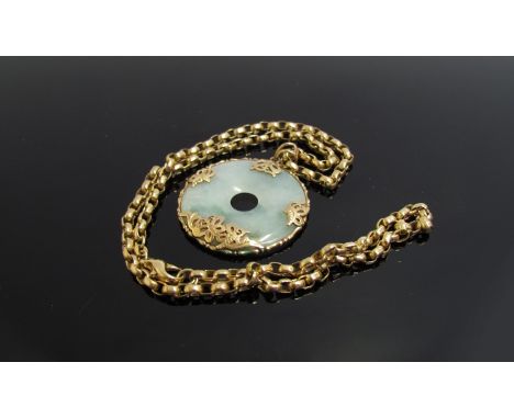 A 9ct gold chain hung with jade bi disc in ornate 9ct gold mount. The chain weighs 11g