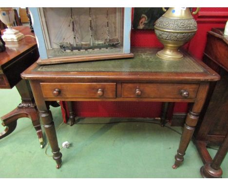 A Victorian mahogany two drawer side table with tooled green leather top, ring turned legs to castors