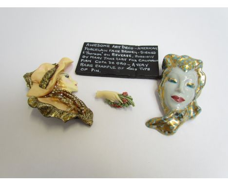 An Art Deco ceramic face brooch signed Theresa on reverse, another marked Helen and hand brooch (3) 