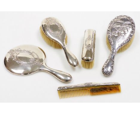 An Edwardian silver backed dressing table set, comprising mirror, hand brush, long brush and a comb, all in similar design wi