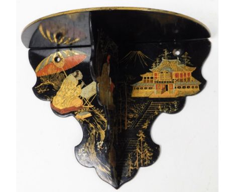 A Victorian papier mache wall shelf, on black ebonised base, with gilt decoration of Oriental figures and buildings, 18cm hig