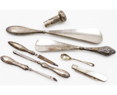 A group of silver handled effects, to include two silver handled shoe horns, one with cherub emblem, a silver handled part ma