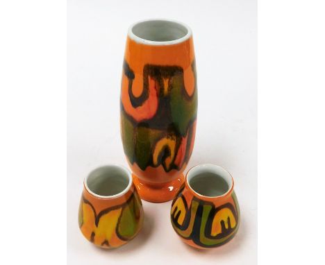 Three Poole vases, in orange ground with yellow and green, 23cm, 8cm, and 10cm high. (3)