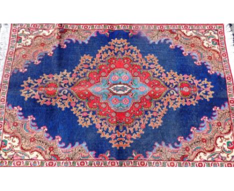 A Persian carpet, on blue ground, overfilled with medallion design, 230cm x 146cm. 