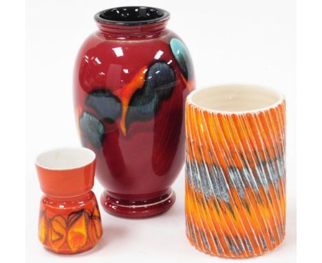 Three Poole pottery vases, to include a red Delphisware vase, 22cm high, an orange flared vase, 15cm high, and a red flambe v