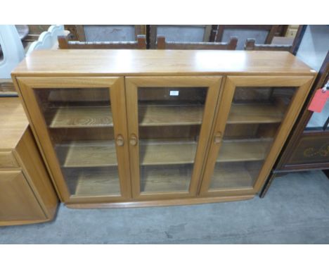 An Ercol Blonde ash three door bookcase 