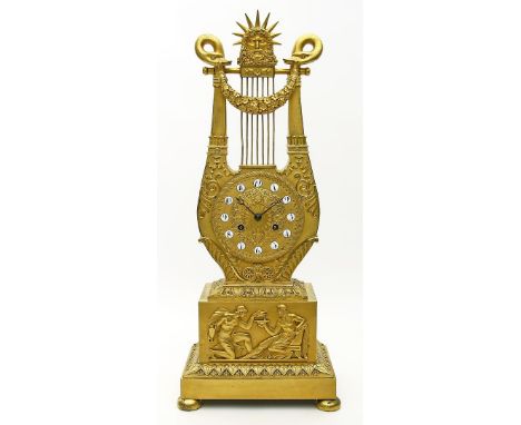 Empire-Pendule in Lyraform. Feuervergoldete Bronze mit feiner Ziselierung. Sockelrelief mit Darstellung nach der Antike. Weiß