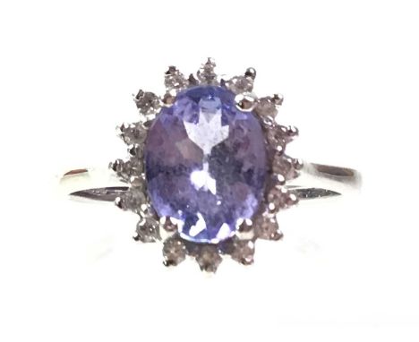 GEMSTONE AND DIAMOND RING, IN EIGHTEEN CARAT GOLD  the central lilac coloured oval stone in a surround of small round diamond
