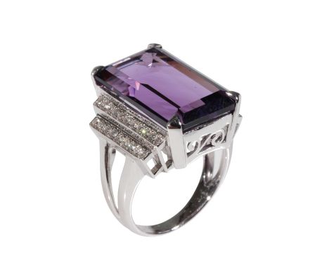 A MODERN AMETHYST AND DIAMOND RING,, the amethyst 20mm x 12mm, claw-set, flanked to either side with double step rows of rub-