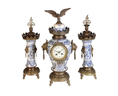A DELFT BLUE AND WHITE GARNITURE DE CHEMINEE, the baluster shaped clock, with white enamel dial and Arabic numerals, enclosin