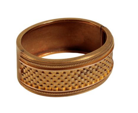 A VICTORIAN ETRUSCAN STYLE YELLOW GOLD BANGLE, half hinged, with concealed clasp, unmarked but tests as gold, in a fitted pre