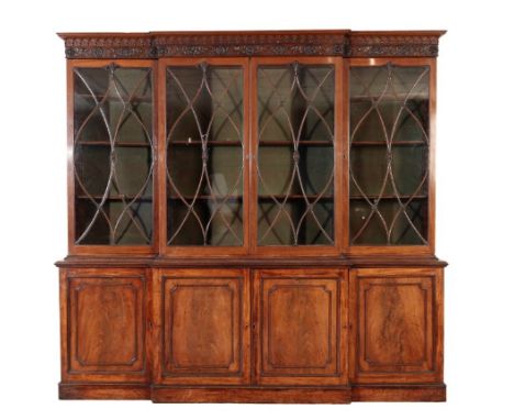 A GEORGE III MAHOGANY AND GLAZED BREAKFRONT BOOKCASE,, late 18th /early 19th century, with Gothic arcaded cornice above a fri