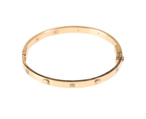 A CARTIER STYLE YELLOW GOLD LOVE BANGLE, the hinged bangle with screw fitment stamped "375", set with six clear stones, possi